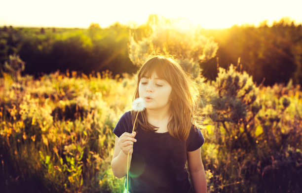 可爱的快乐有希望的女孩在大自然的户外与一个大蒲公英花许愿图片下载