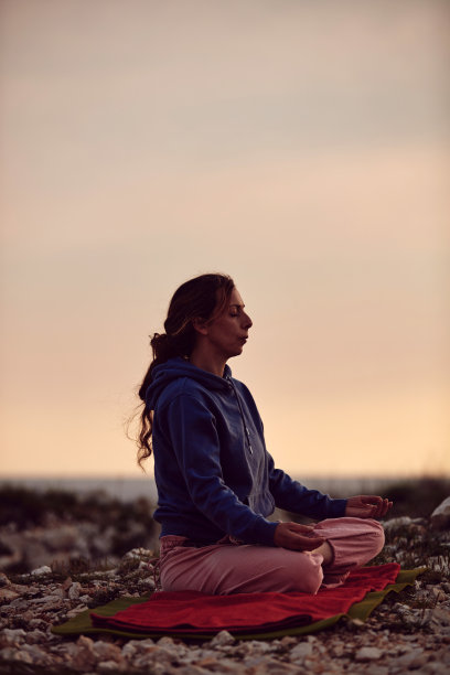 女子在日落日出的时候在户外练习瑜伽。图片下载