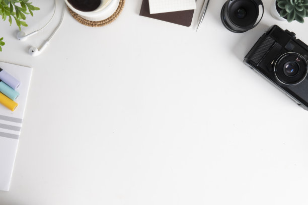 将相机、咖啡杯、文具和盆栽平铺在白色的桌子上。创意工作场所，俯视图与复制空间。图片下载