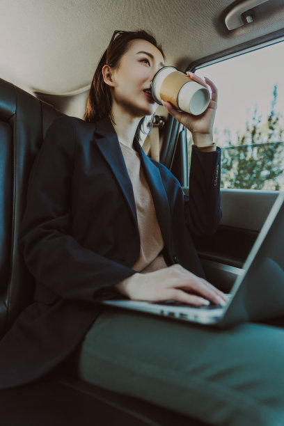 商务女乘用车在后座。图片下载