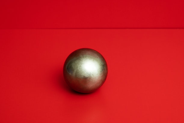 一个闪亮的彩色球与阴影在红色的背景图片下载