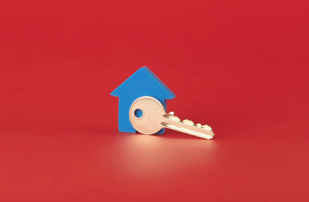 房子的钥匙与蓝色的房子孤立的红色背景图片下载