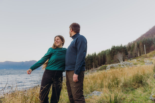 一个女人和一个男人在海边凝视着快乐的日落时分图片下载