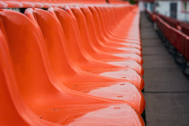 体育场里有一排空座位，橙色的座位。座位选择性聚焦图片下载
