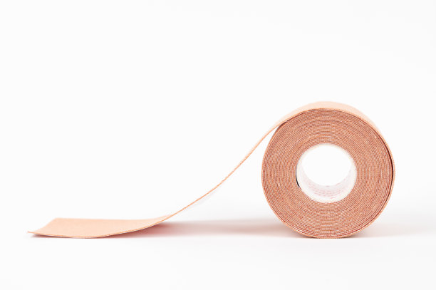 米色运动机能学磁带隔离在白色。理疗和治疗胶带疼痛和紧张。图片下载