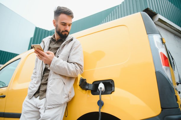 男子正在给他的电动汽车充电。图片下载