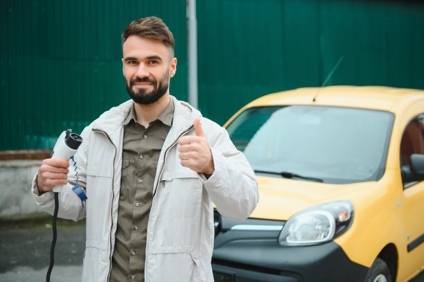 男子在工作时给电动汽车充电图片下载