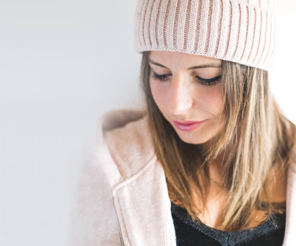 一个戴着帽子的白人妇女的特写，向下看。害羞的概念。图片下载