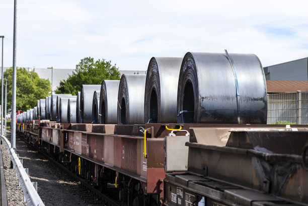 大金属片:由火车头拉着的货车上的大金属片卷图片下载