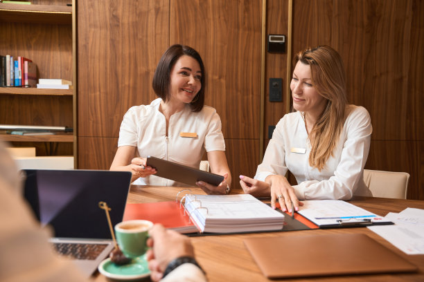 女医生们拿着笔记本电脑坐在桌子旁图片下载