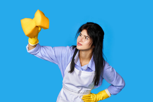 女人戴手套和清洁围裙与清洁剂喷雾器图片下载