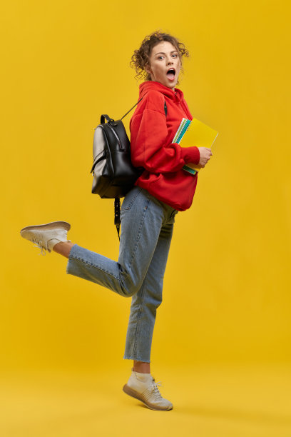 学生拿着书站着，抬腿。图片下载