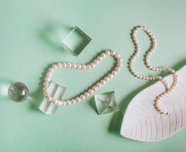 珍珠在绿色背景与复制空间。项链珠宝。图片下载