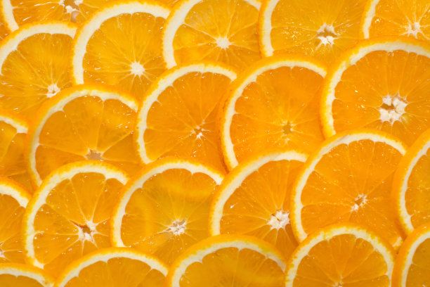 鲜亮的橘色背景来自多汁的橘片。健康食品，背景。图片下载