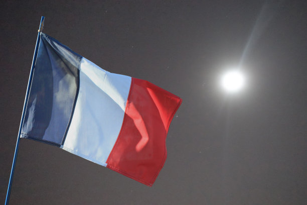法国国旗在满天繁星的月圆之夜随风飘扬图片下载