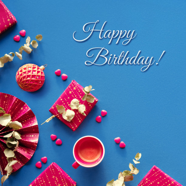 生日快乐在冬天，十二月，一月，二月。品红礼品盒，纸扇，桉树，心形糖。方形几何角组成，平铺在深蓝色的纺织背景上。图片下载