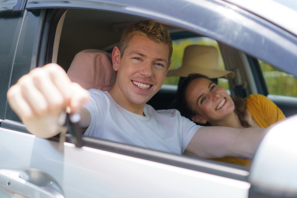 白人男子购买新车或租来的车，并出示钥匙，坐在车里。图片下载