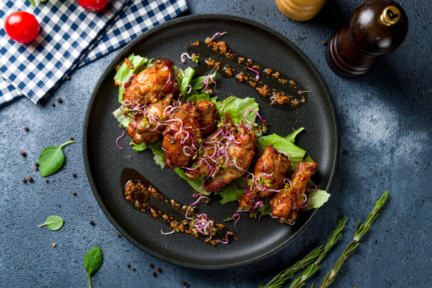 黑盘子上的烤肉酱鸡翅图片下载