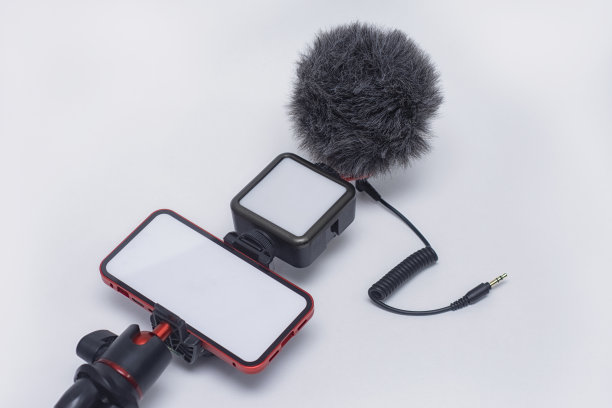 一套博客小工具。智能手机模型，白色屏幕，三脚架，白色背景上有灯和麦克风。图片下载