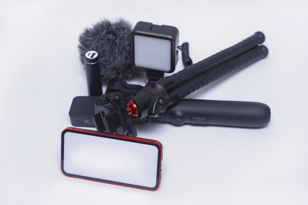 一套博客小工具。智能手机模型，白色屏幕，三脚架充电宝，带有活动摄像头，白色背景上有麦克风的稳定器。图片下载