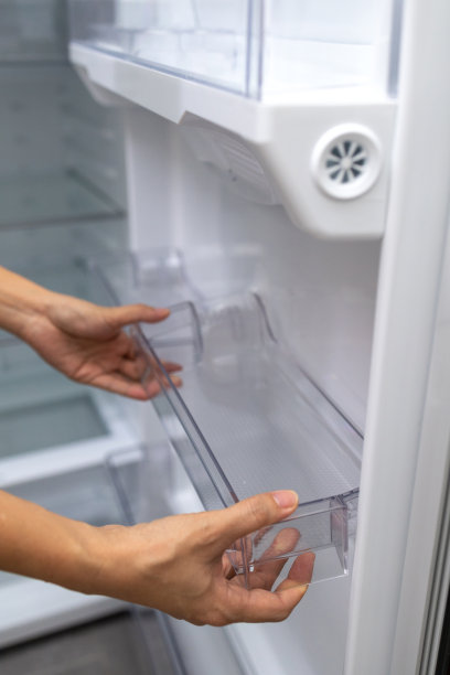 女性的手在冰箱里固定一个干净的塑料托盘图片下载