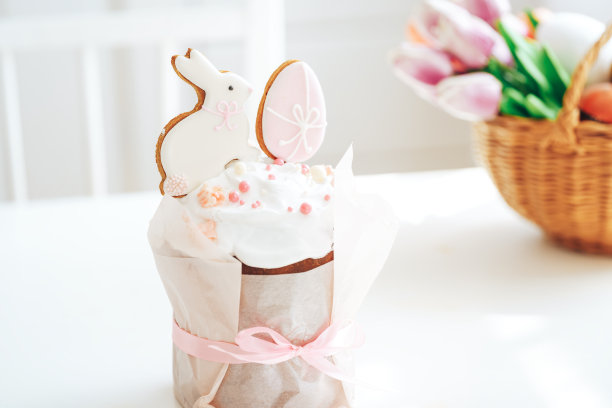 用蝴蝶结系在复活节蛋糕上的兔子和鸡蛋形状的饼干图片下载
