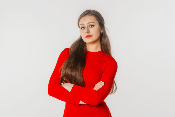 一个黑发女孩，双臂交叉，愤怒地看着镜头，不同意别人的观点。摄影棚拍摄，白色背景图片下载