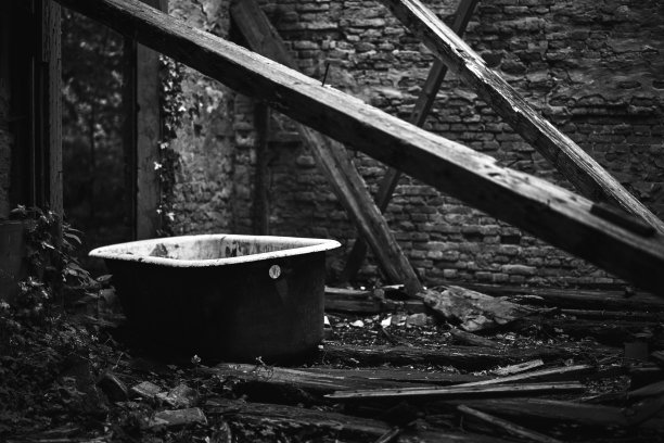 灰色镜头的旧乡村垃圾损坏浴缸在地上在一个废弃的建筑图片下载