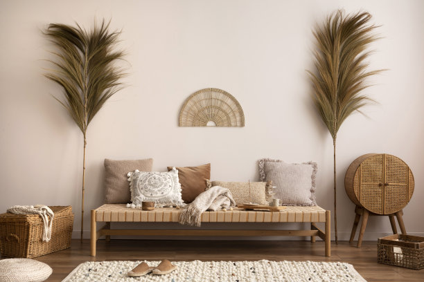 波西米亚构图的冥想客厅内部与沙发，米色地毯，枕头，饰品和个人配件。家居装饰。模板。图片下载