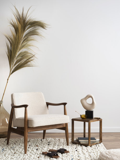 室内设计具有美学和极简主义的客厅，有毛线扶手椅，木制咖啡桌，花瓶，装饰和个人配件中的美丽叶子。副本的空间。家居装饰。图片下载