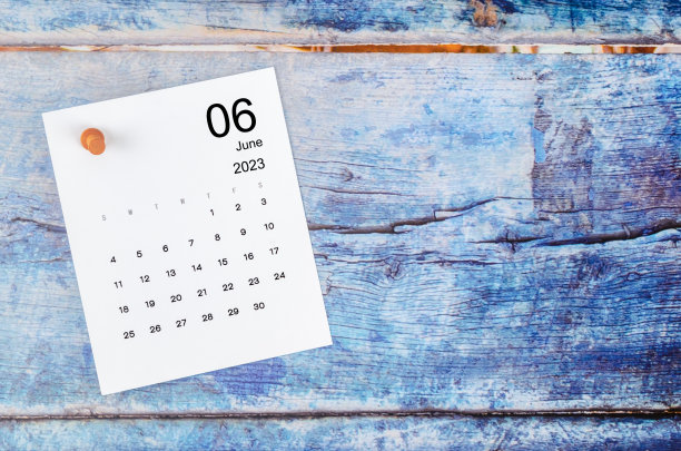 2023年6月的月历和蓝色木制背景的木制推销。图片下载