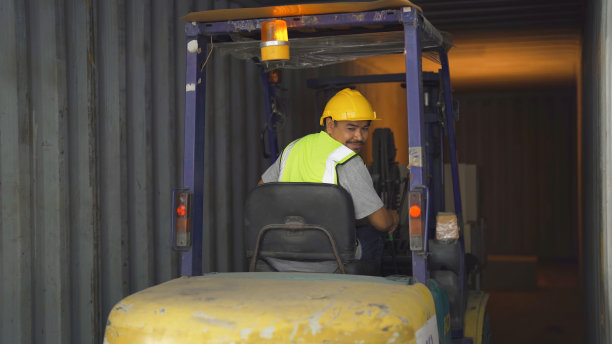 在仓库零售商店行业驾驶叉车和托盘车的工人。货架库存储存。电子商务和物流货运。仓库。人们的生活方式。集装箱运输服务图片下载