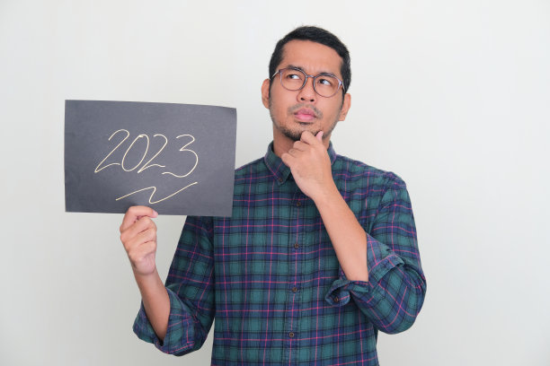 成年亚洲男子拿着2023文本的纸展示思考姿势图片下载