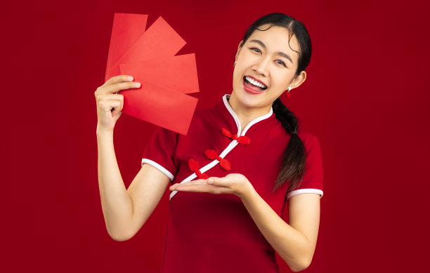 中国新年概念，年轻的亚洲妇女在红色传统中国服装拿着红包。图片下载