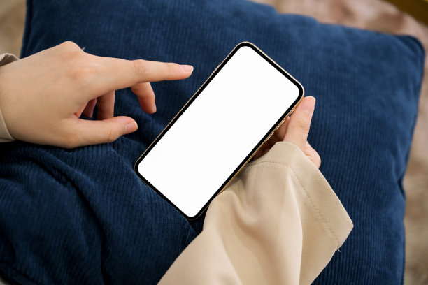 特写图片，女性在客厅里使用智能手机。图片下载