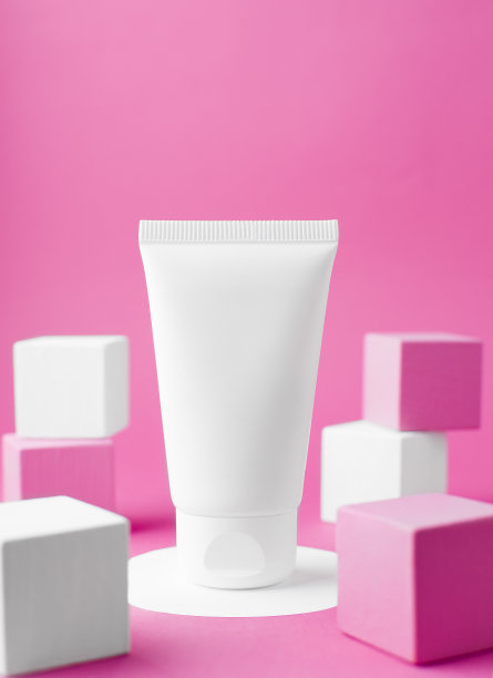 在一个圆形的架子上有一个白色的乳白色管的模型，旁边是粉色和白色的讲台。创意化妆的照片。图片下载