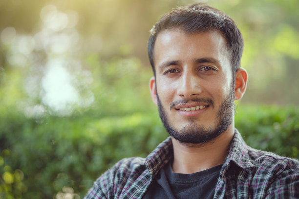 户外的一天肖像一个快乐的年轻人看着相机。图片下载