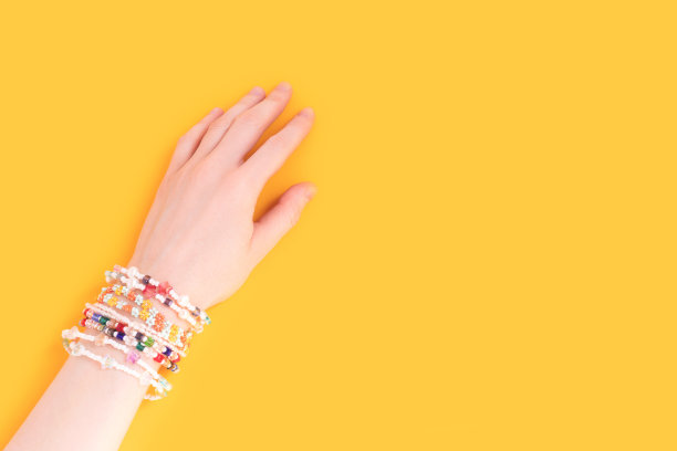 戴着很多手镯的女人的手。图片下载