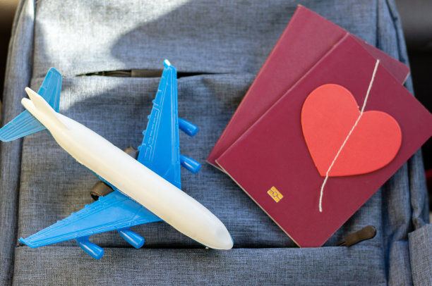 纸心花环香槟玻璃桌子护照飞机玩具。浪漫旅行概念红心图案贺卡图片下载