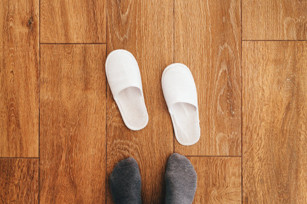 酒店房间内有男士脚和一次性白色拖鞋图片下载