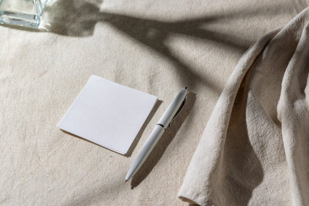 空白纸卡与模型复制空间和中性米色亚麻毯子上的花卉阴影。极简美学的商业品牌模板。平铺，俯视图图片下载