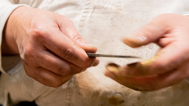 工匠检查小武士刀的刀刃锋利度图片下载