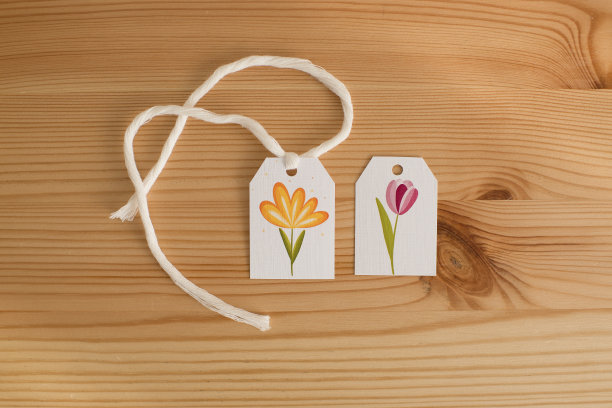 一个标签上有一朵花的图片在木桌上，俯视图。图片下载