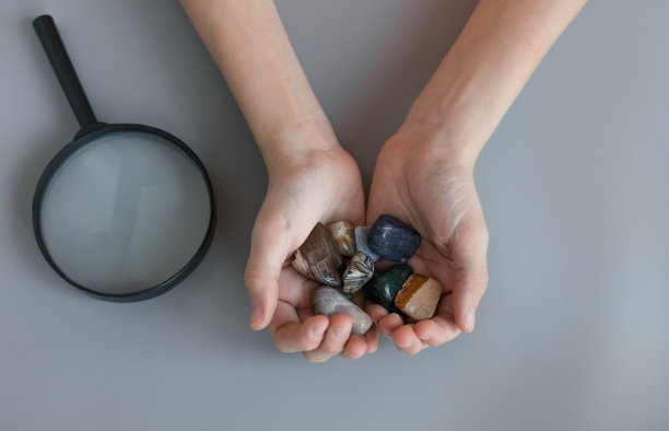 孩子在灰色的桌子上，手里拿着各种各样的半宝石图片下载