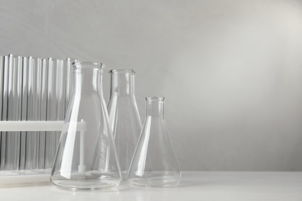 白色桌子上的实验室玻璃器皿，灰色背景，文字空间图片下载