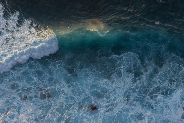 日落时被太阳照亮的巨浪。海浪非常适合冲浪。图片下载