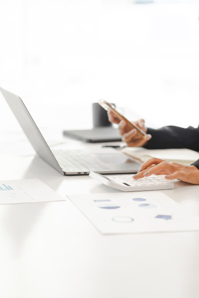 商业女性使用计算器工作与财务报告。图片下载