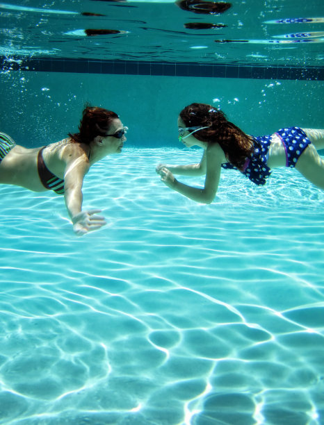 妈妈和小女儿夏天在水下游泳池里玩图片下载
