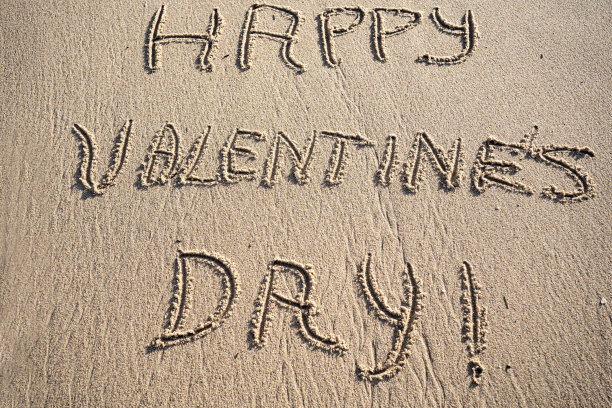 情人节快乐写在热带海滩的沙滩上图片下载