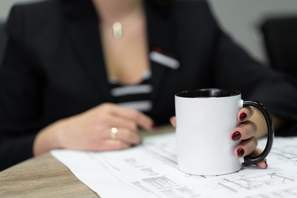 图为，建筑公司的工作人员端着一杯茶观看施工图。图片下载